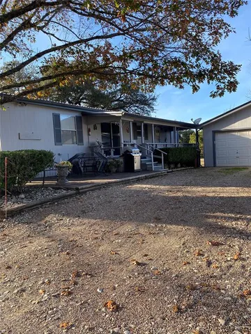 a front view of a house with yard and parking space