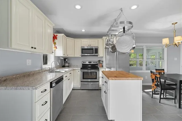 a kitchen with stainless steel appliances granite countertop a sink a stove and refrigerator