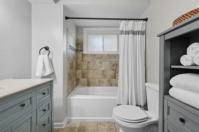 a view of an empty room with a window and kitchen view