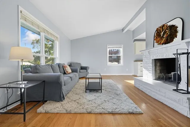 a living room with furniture a fireplace and kitchen view