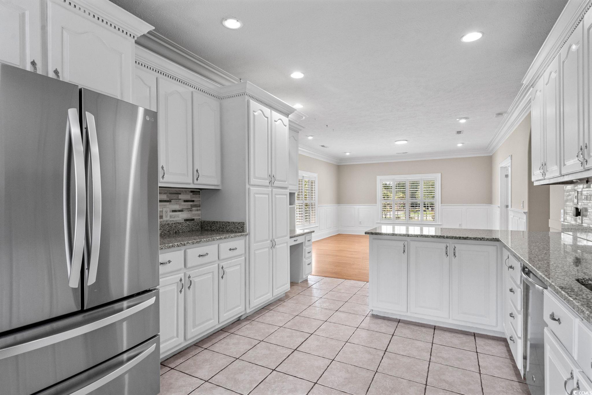 6912 Bay Road Myrtle Beach, SC 29588 - Photo 14 of 38 Kitchen featuring wainscoting, freestanding refrigerator, ornamental molding, white cabinetry, and recessed lighting