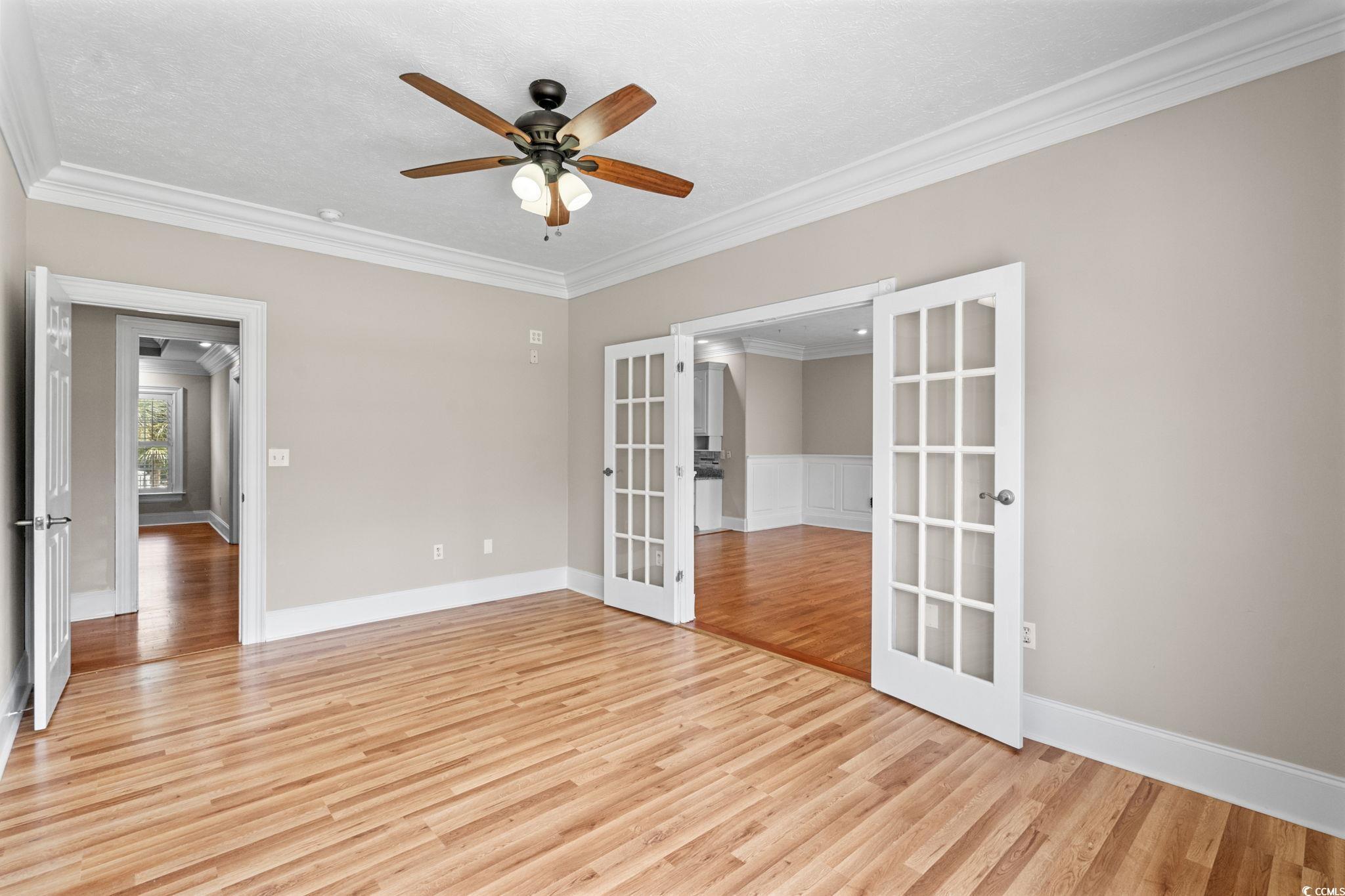6912 Bay Road Myrtle Beach, SC 29588 - Photo 18 of 38 Spare room with french doors, ornamental molding, light wood finished floors, a ceiling fan, and a textured ceiling
