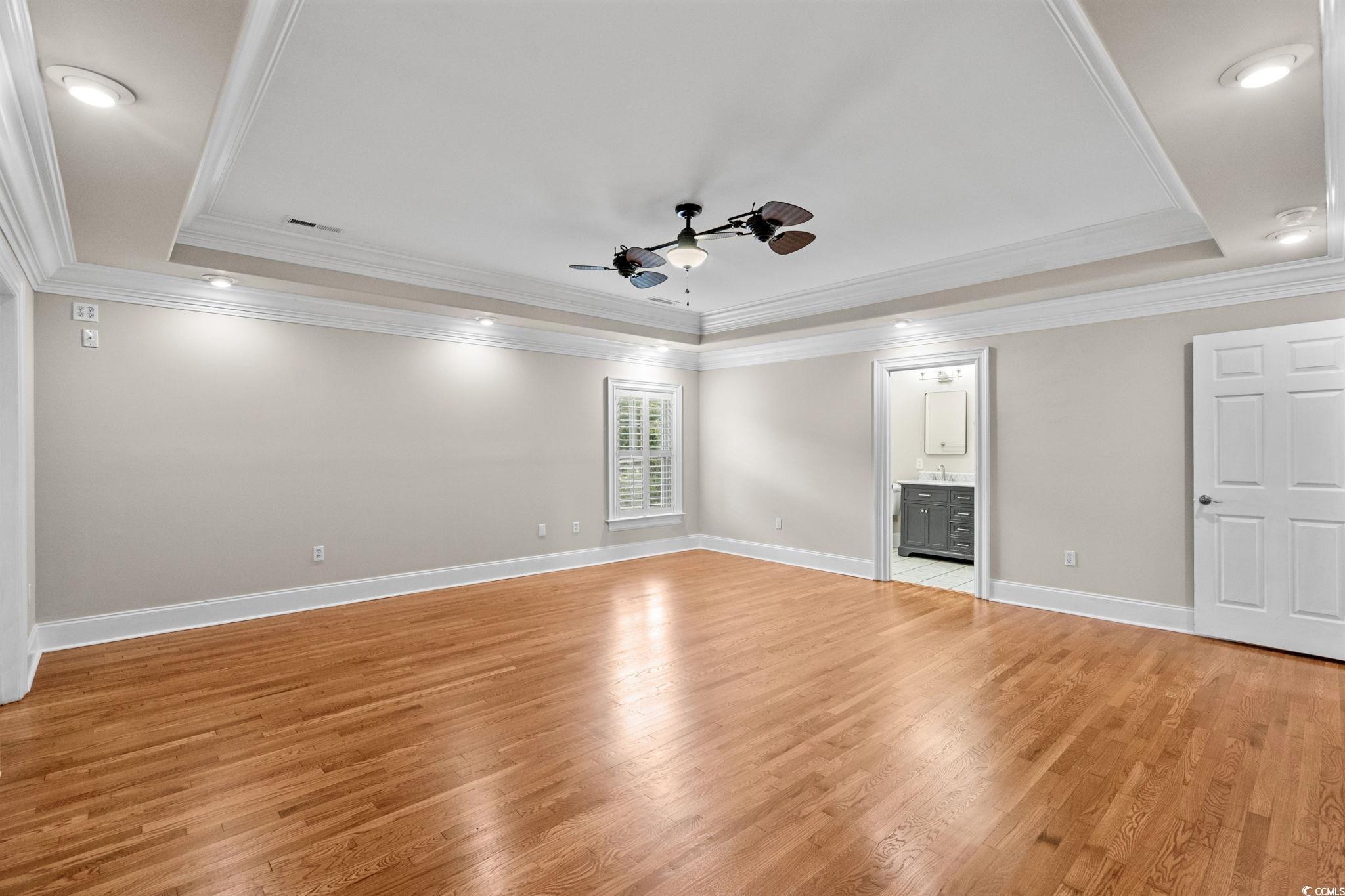 6912 Bay Road Myrtle Beach, SC 29588 - Photo 20 of 38 Primary Bedroom with a tray ceiling, ornamental molding, unusual ceiling fan, light wood-style floors, and recessed lighting