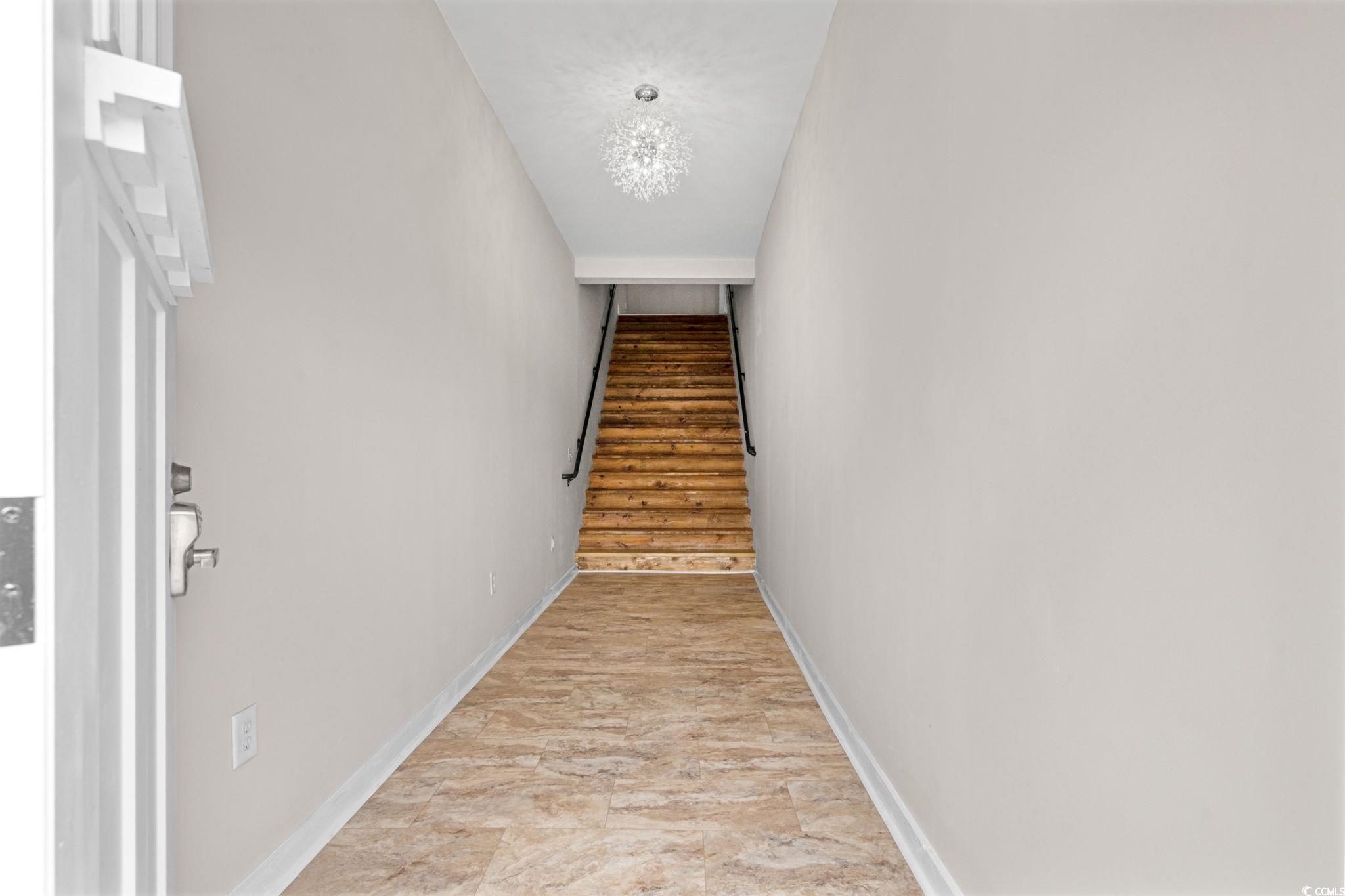 6912 Bay Road Myrtle Beach, SC 29588 - Photo 2 of 38 Hall with stairs and a chandelier