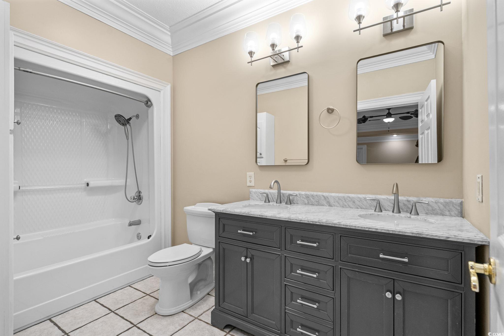6912 Bay Road Myrtle Beach, SC 29588 - Photo 22 of 38 Primary full bath featuring ornamental molding, double vanity, shower / bath combination, and tile patterned flooring