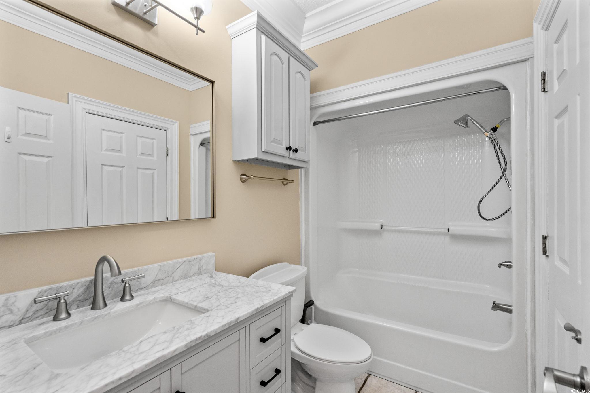 6912 Bay Road Myrtle Beach, SC 29588 - Photo 23 of 38 Full bath with ornamental molding, vanity, and bathtub / shower combination