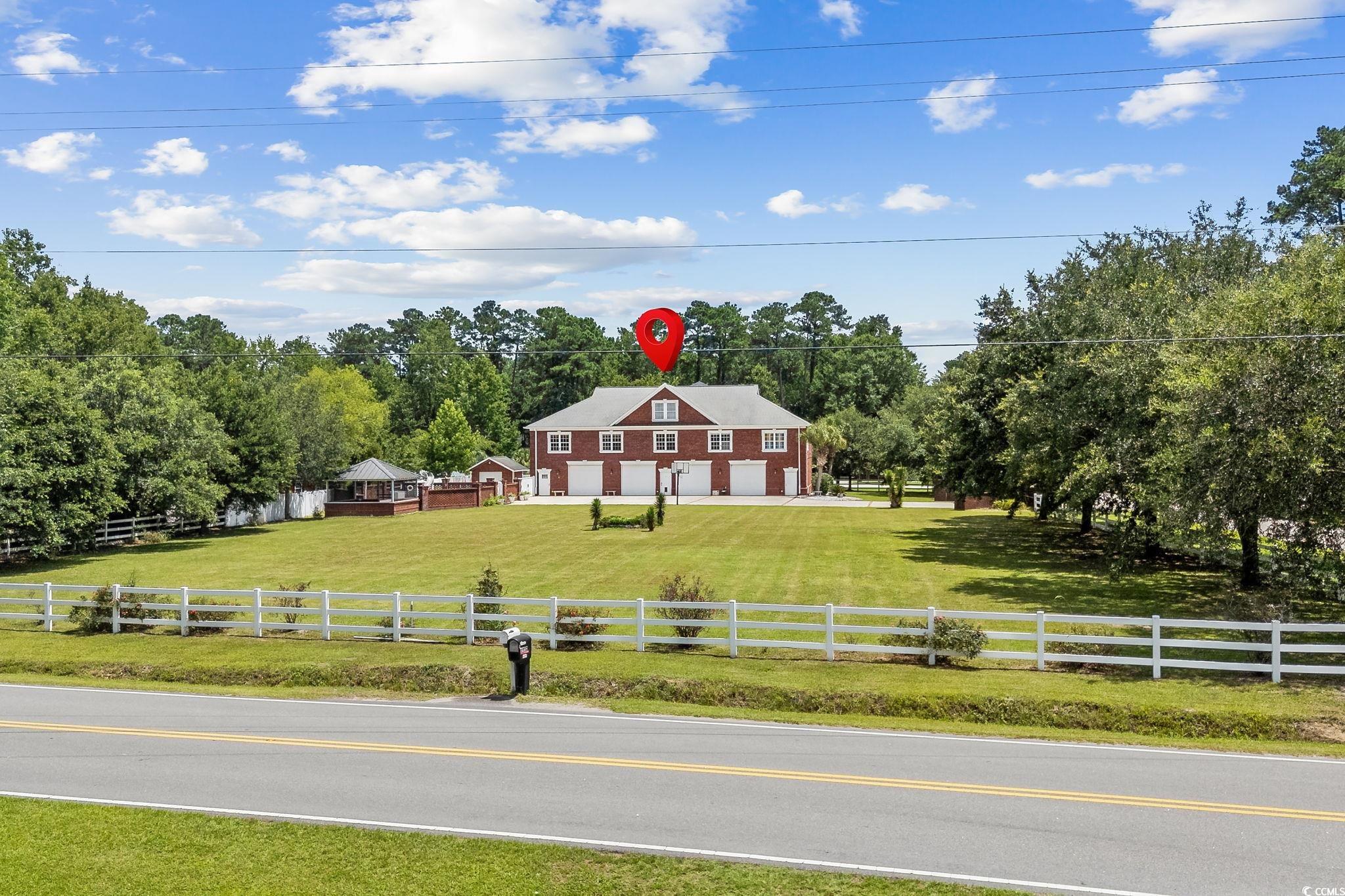 6912 Bay Road Myrtle Beach, SC 29588 - Photo 35 of 38 View of front of property with a view of rural / pastoral area, a garage, a fenced front yard, and driveway
