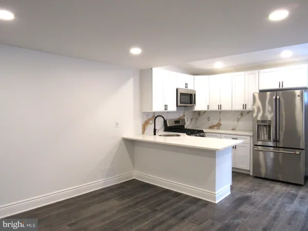 a kitchen with a refrigerator sink and white cabinets