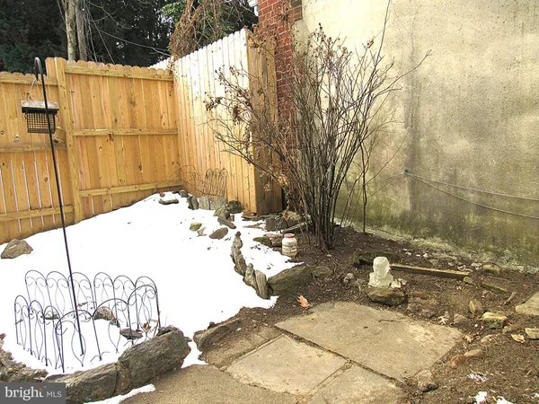 a view of a brick house with wooden fence