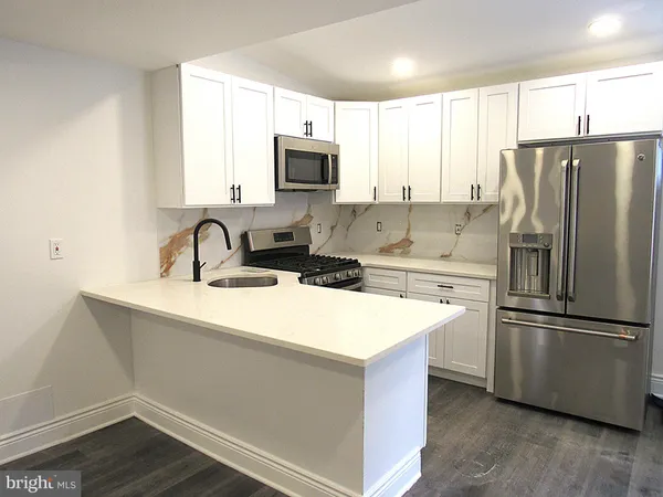 a kitchen with appliances a sink and a counter top space