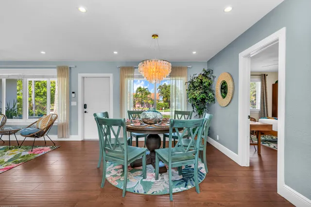 a living room with furniture and a dining table with wooden floor
