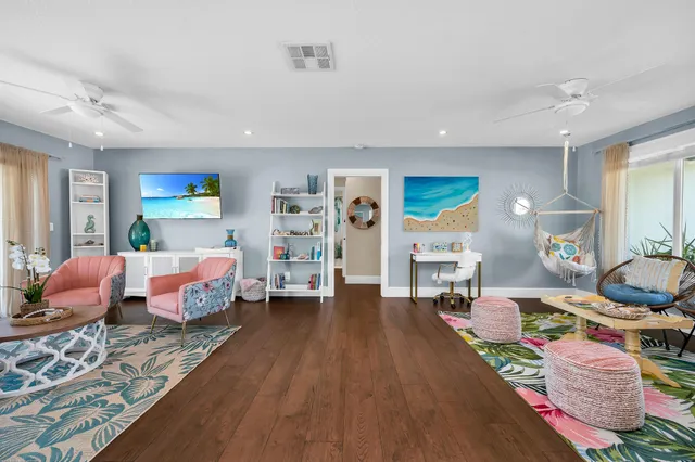 a living room with furniture and a large window with kitchen view