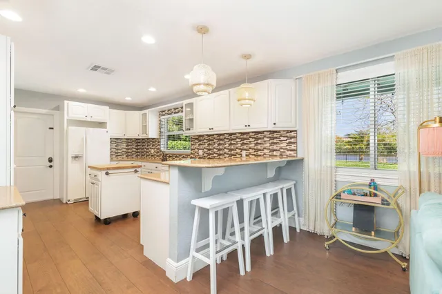 a kitchen with stainless steel appliances granite countertop a sink and a refrigerator