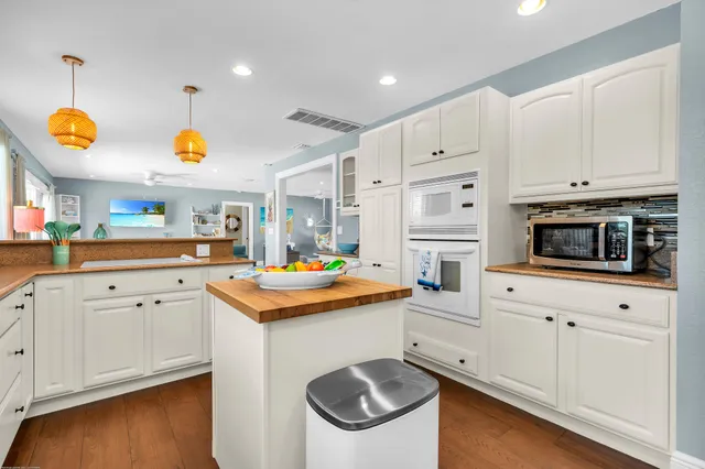 a kitchen with white cabinets and white appliances