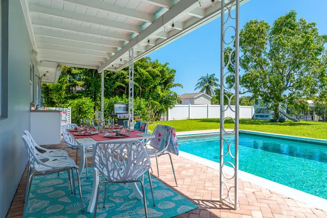 a view of a patio with a table and chairs under an umbrella