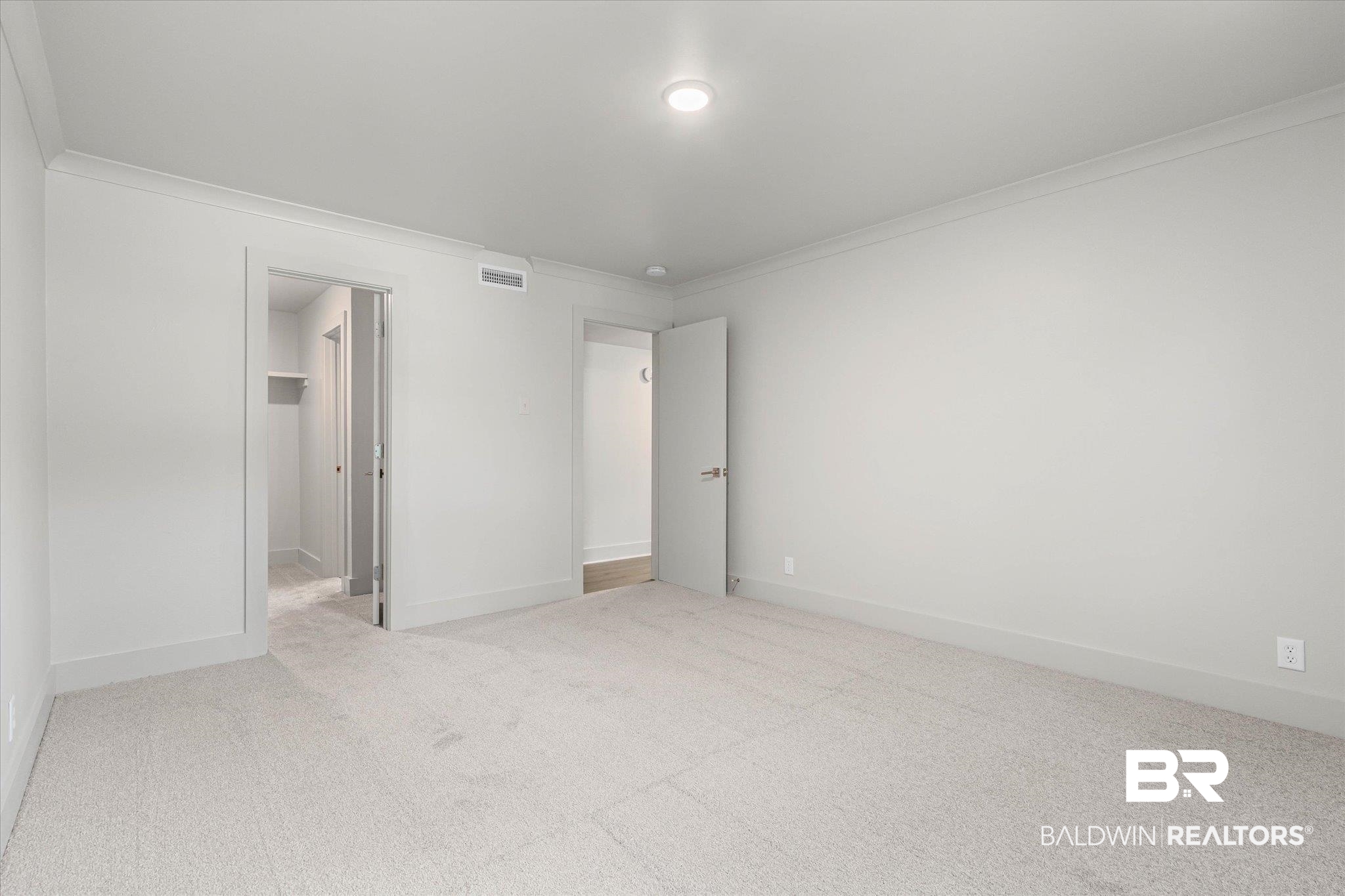 3655 Old Shell Road, Unit 712 Mobile, AL 36608 - Photo 11 of 19 Unfurnished bedroom with a walk in closet, light carpet, and crown molding
