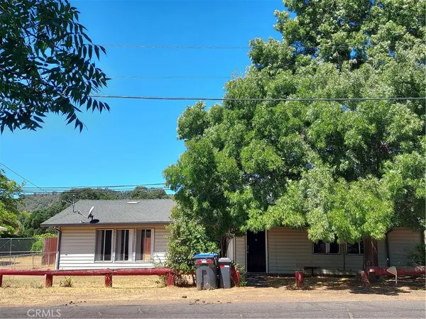 a view of a house with a street and trees
