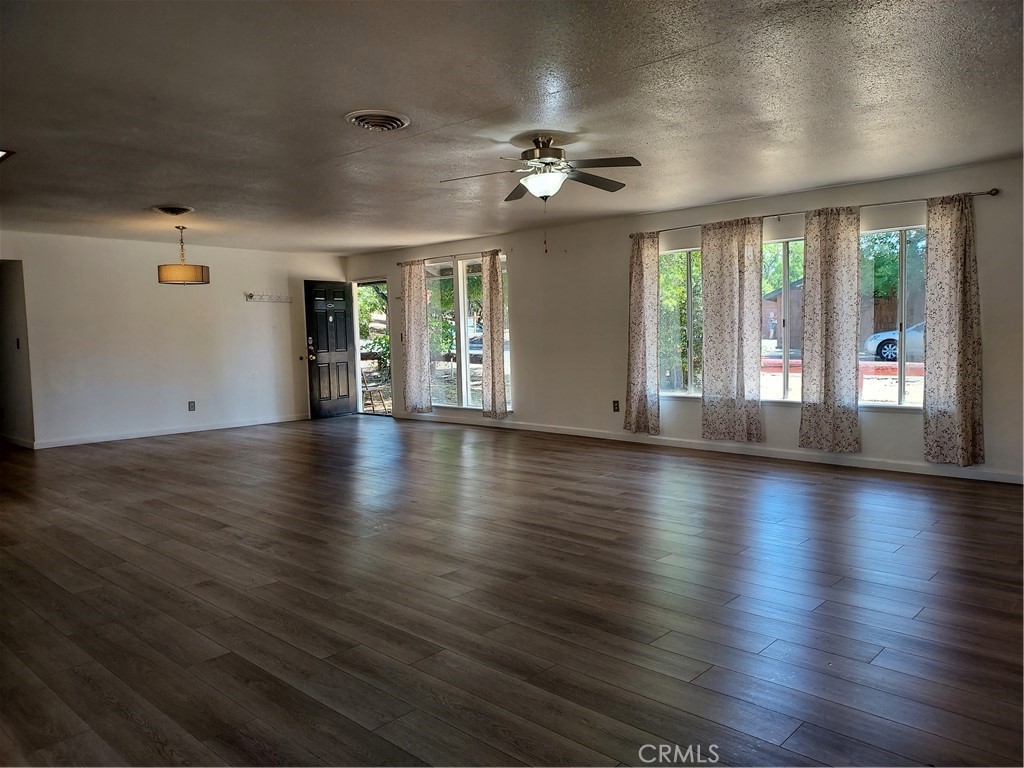 6135 Ridgeview Drive Clearlake, CA 95422 - Photo 11 of 36 an empty room with wooden floor and windows