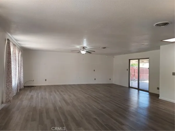 a view of a kitchen with refrigerator and wooden floor