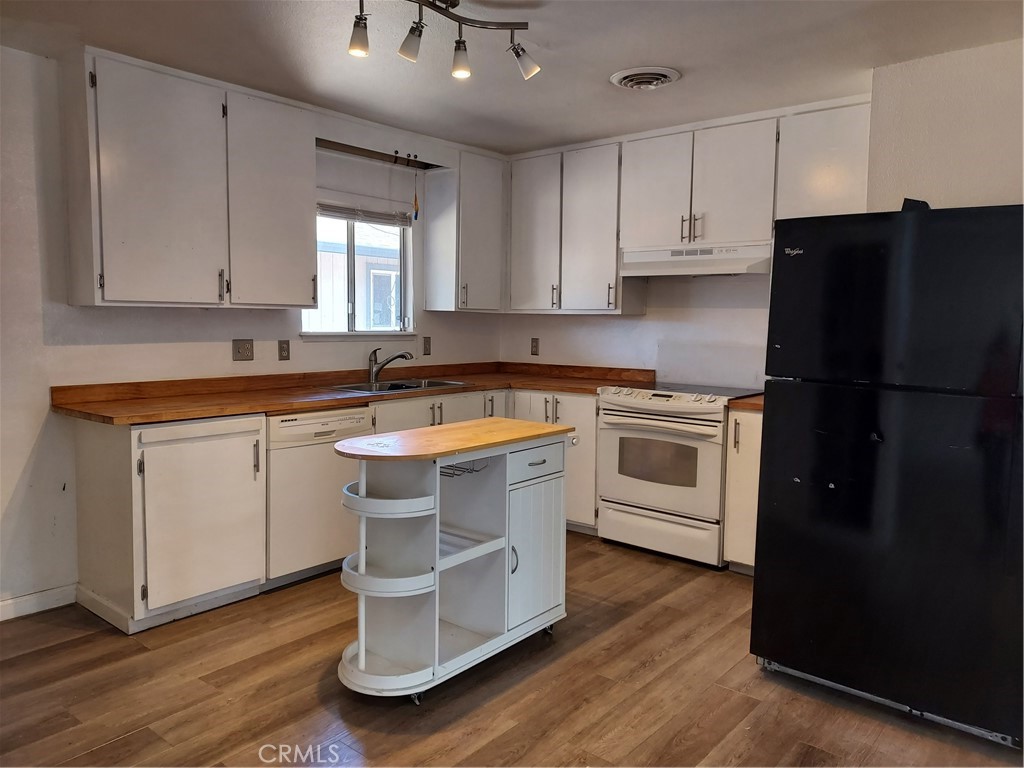 6135 Ridgeview Drive Clearlake, CA 95422 - Photo 16 of 36 a kitchen with white cabinets and white appliances
