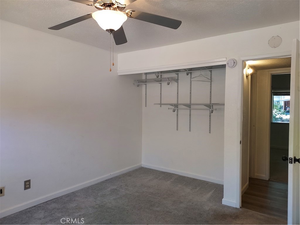 6135 Ridgeview Drive Clearlake, CA 95422 - Photo 20 of 36 an empty room with closet and chandelier fan