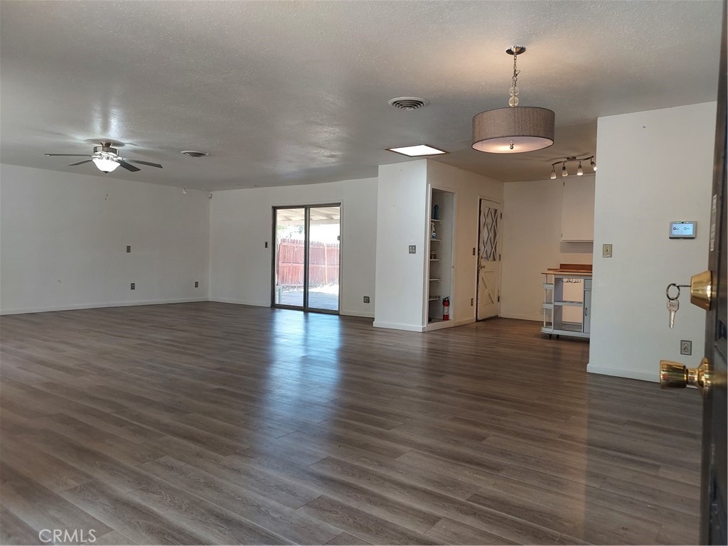 6135 Ridgeview Drive Clearlake, CA 95422 - Photo 8 of 36 an empty room with wooden floor chandelier and windows