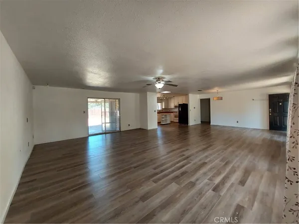 a view of an empty room with window and wooden floor