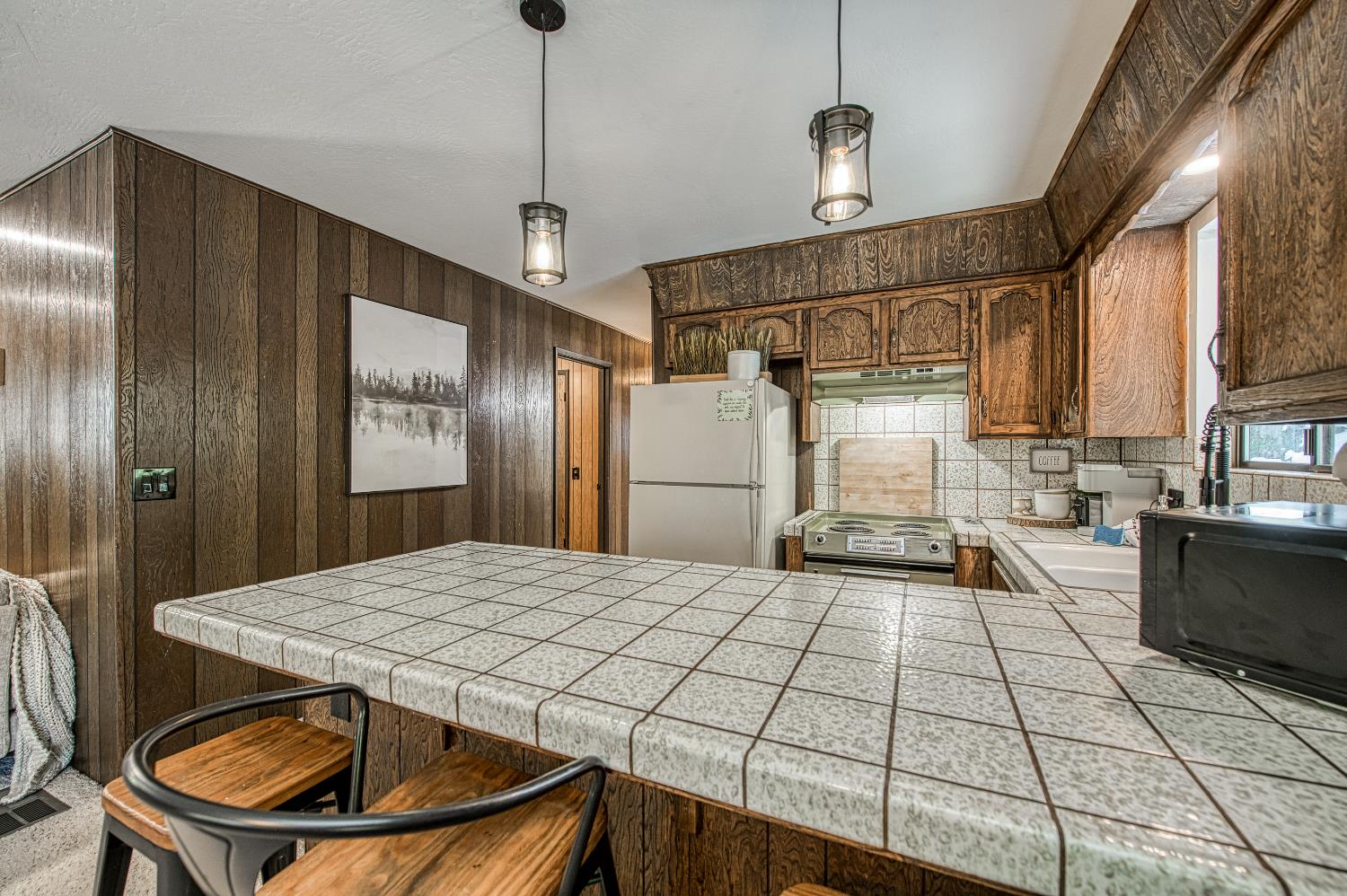 42488 Rock Ledge Road Shaver Lake, CA 93664 - Photo 14 of 37 a kitchen with a sink a refrigerator and cabinets