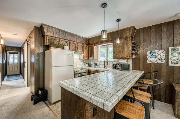 a kitchen with a table chairs refrigerator and microwave