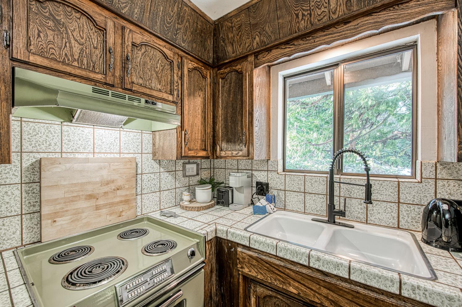 42488 Rock Ledge Road Shaver Lake, CA 93664 - Photo 17 of 37 a kitchen with a stove a sink and a cabinets