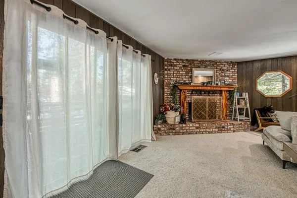 a view of an empty room with a fireplace and dining room
