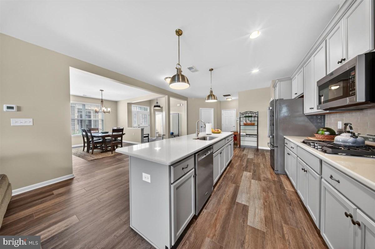 1426 Whispering Woods Road Middletown, DE 19709 - Photo 12 of 37 a large kitchen with stainless steel appliances granite countertop a lot of counter space and wooden floors