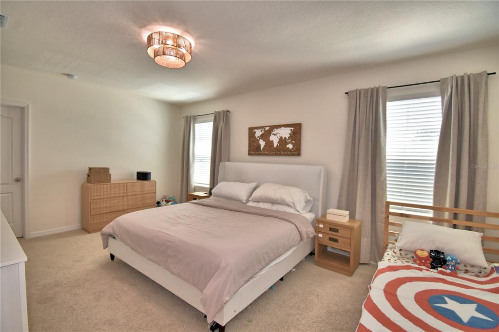 2839 Moulin Road Davenport, FL 33837 - Photo 34 of 75 a bedroom with a bed and a chandelier