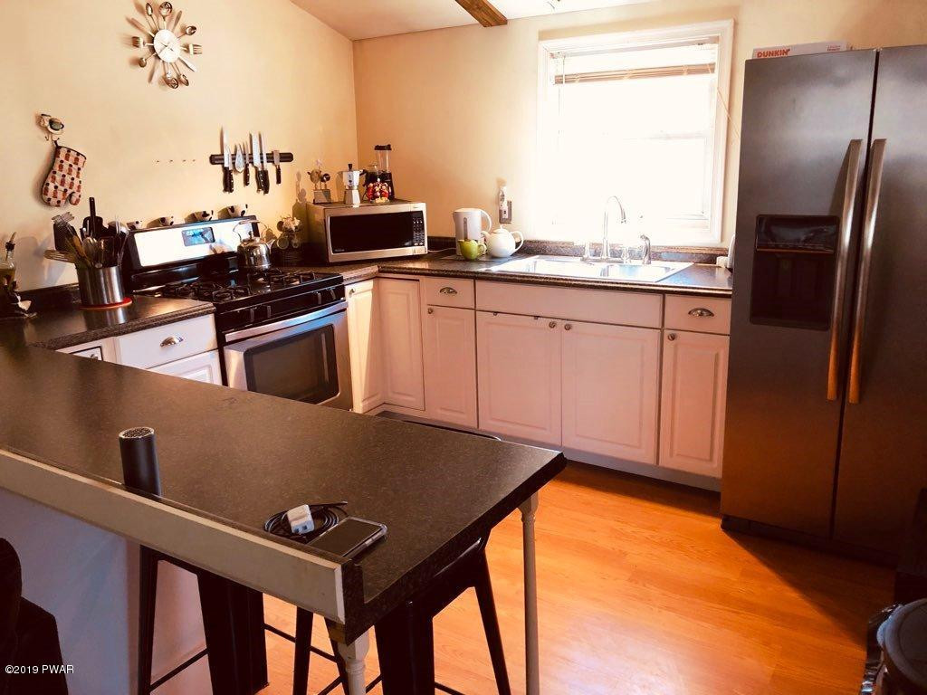 148 Roundhill Road Dingmans Ferry, PA 18328 - Photo 6 of 24 a kitchen with stainless steel appliances a stove a sink and a refrigerator