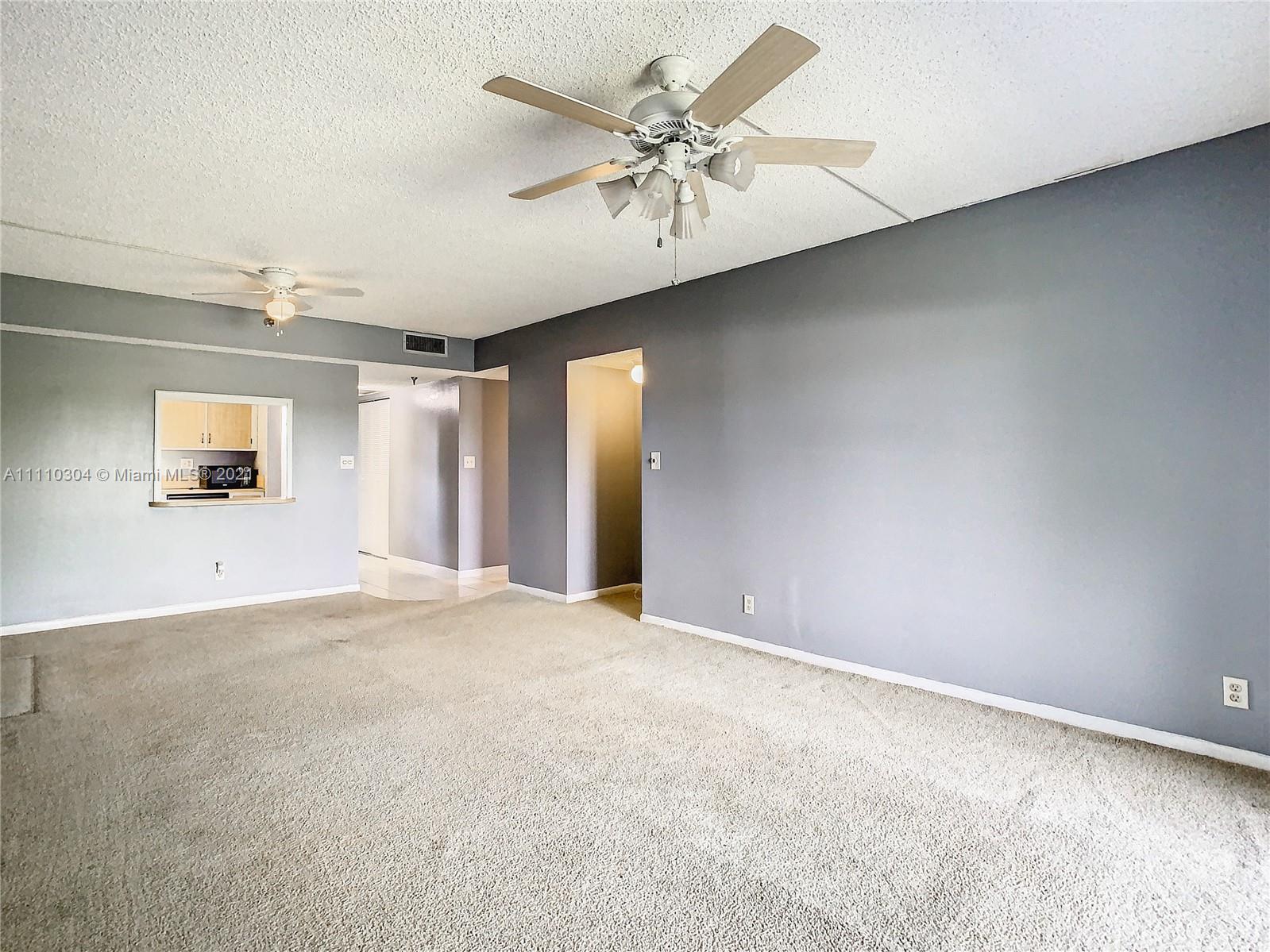 9235 Southwest 8th Street, Unit 401 Boca Raton, FL 33428 - Photo 14 of 40 an empty room with a ceiling fan and windows