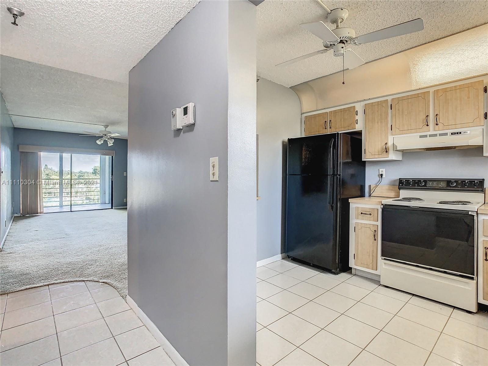 9235 Southwest 8th Street, Unit 401 Boca Raton, FL 33428 - Photo 15 of 40 a kitchen with stainless steel appliances a refrigerator and a stove top oven