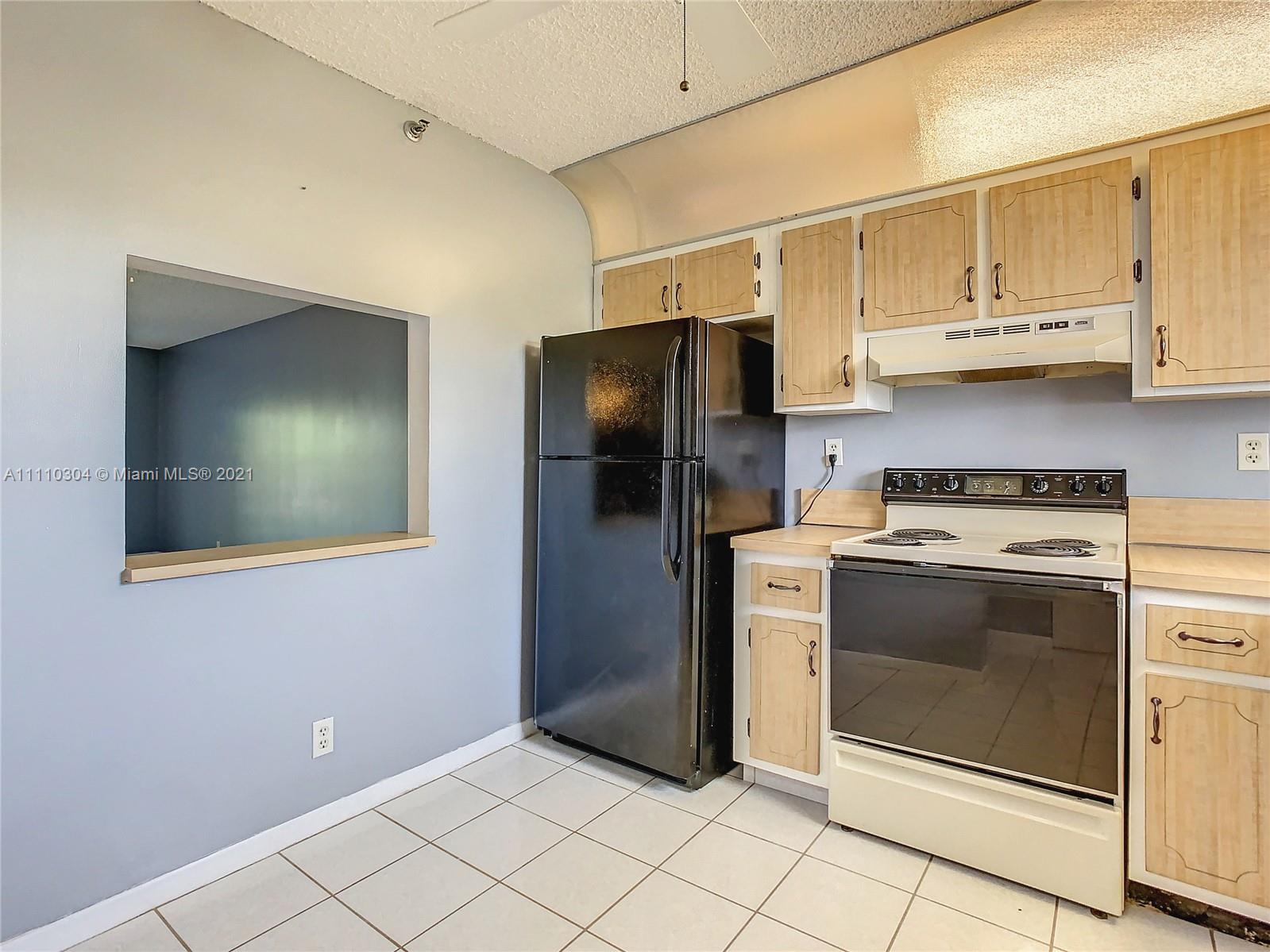 9235 Southwest 8th Street, Unit 401 Boca Raton, FL 33428 - Photo 16 of 40 a kitchen with stainless steel appliances a stove a refrigerator and cabinets