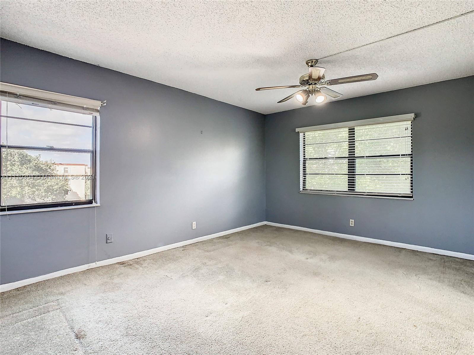 9235 Southwest 8th Street, Unit 401 Boca Raton, FL 33428 - Photo 22 of 40 an empty room with windows and fan