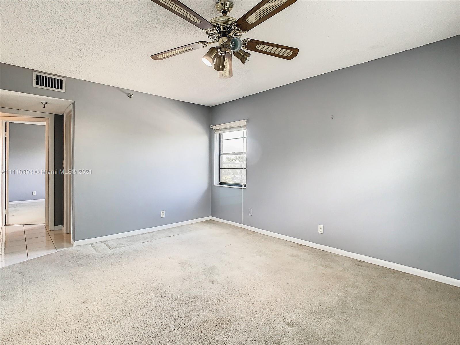 9235 Southwest 8th Street, Unit 401 Boca Raton, FL 33428 - Photo 24 of 40 an empty room with windows and fan