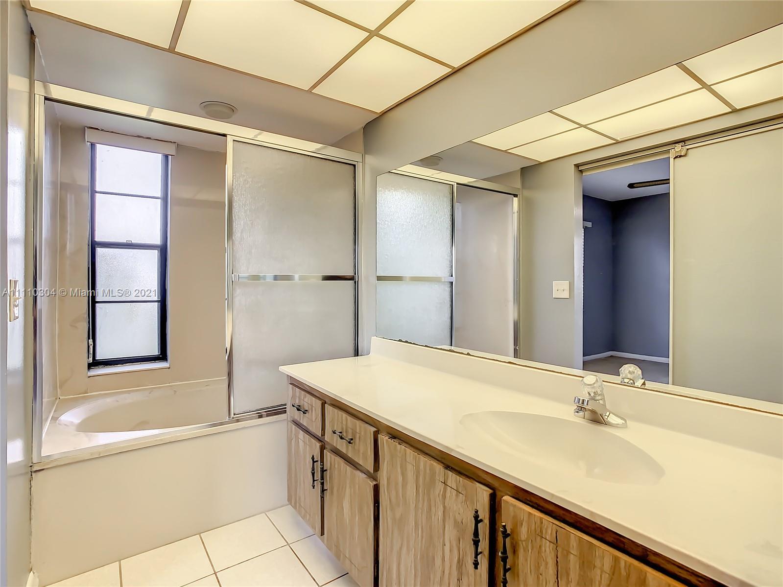 9235 Southwest 8th Street, Unit 401 Boca Raton, FL 33428 - Photo 28 of 40 a bathroom with a granite countertop sink and a bathtub