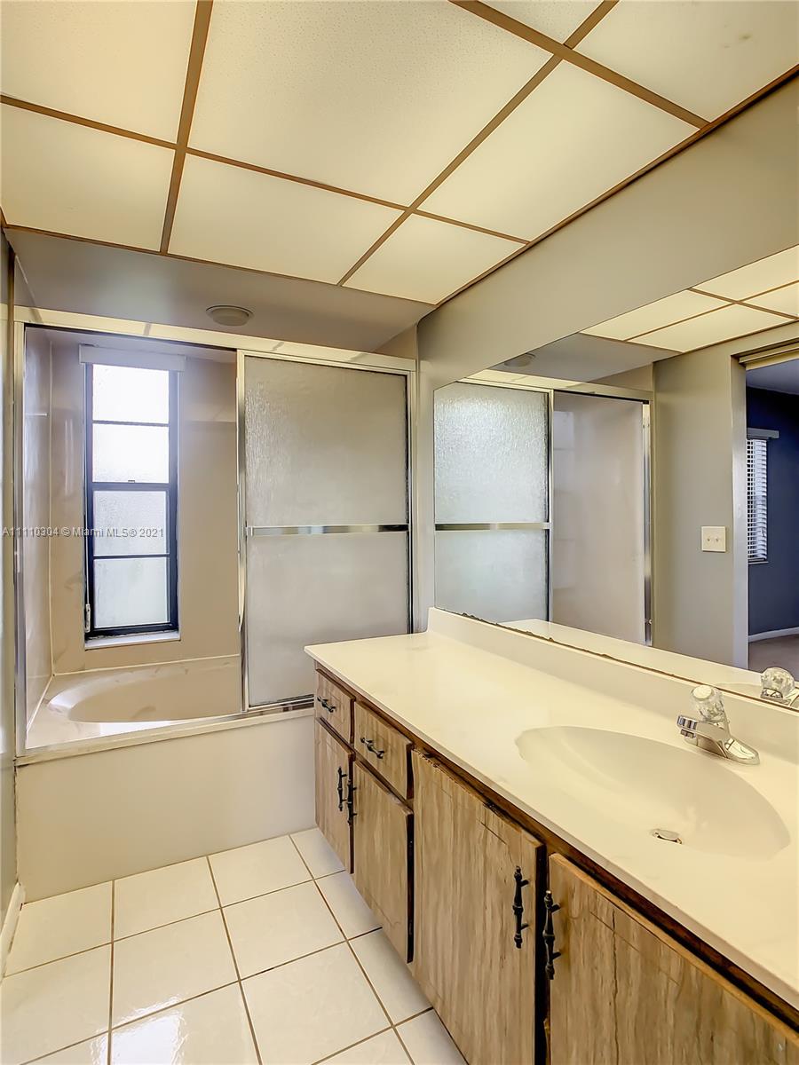 9235 Southwest 8th Street, Unit 401 Boca Raton, FL 33428 - Photo 30 of 40 a bathroom with a granite countertop sink mirror and bathtub