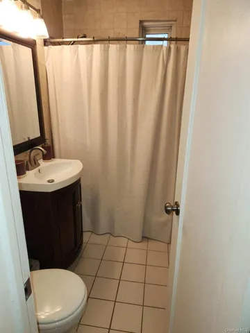 a bathroom with a sink a toilet a mirror and shower curtain