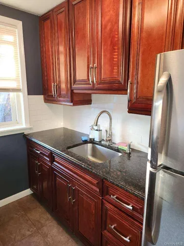 a kitchen with stainless steel appliances granite countertop a sink refrigerator and cabinets