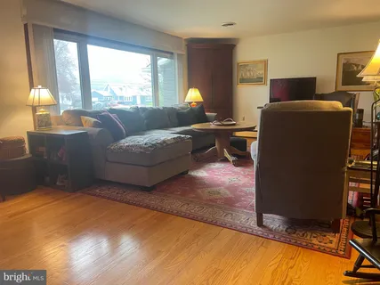 a living room with furniture a large window and a flat screen tv