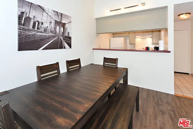 a living room with kitchen view and wooden floor