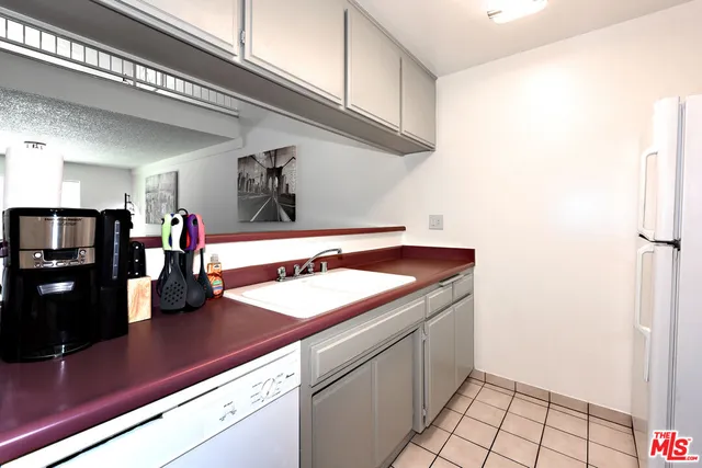 a kitchen with stainless steel appliances granite countertop a sink and a refrigerator