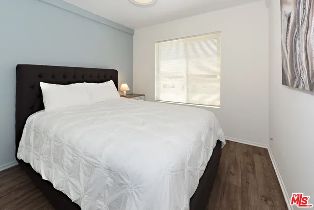 a large bed sitting in a bedroom next to a window