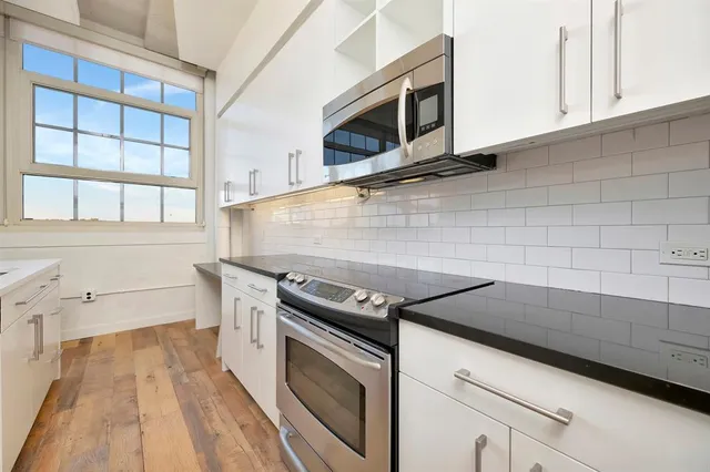 a kitchen with granite countertop white cabinets stainless steel appliances and sink