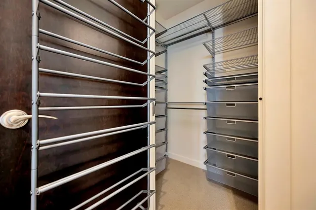 a view of walk in closet with empty racks