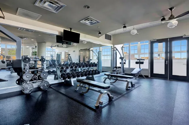 a living room with lots of furniture hardwood floor and a ceiling fan